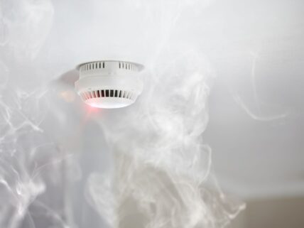 a cloud of smoke around fire alarm.