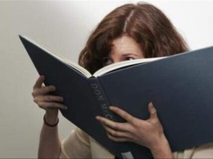 woman smelling book.