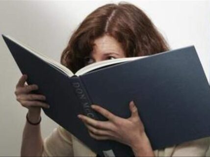 woman smelling book.